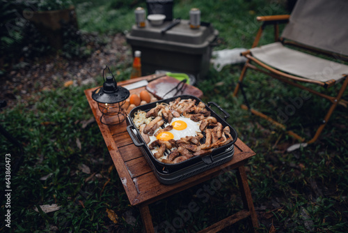 Fried eggs and grilled pork in a camping pan