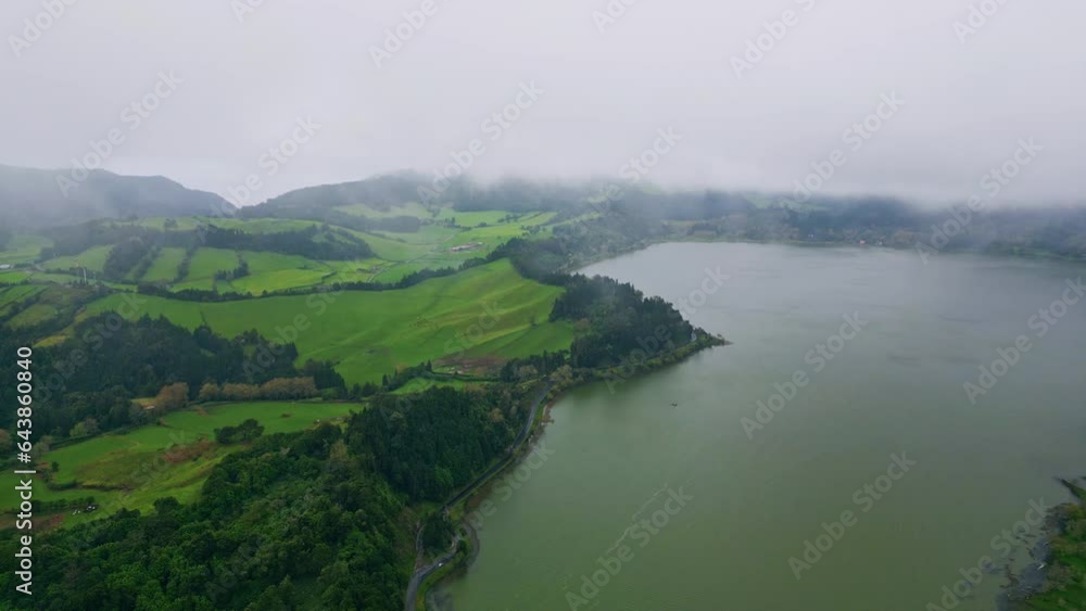 Greenery slopes gloomy lake meeting aerial. Heavy clouds covering green hills Greenery slopes gloomy lake meeting aerial. Heavy clouds covering green hills