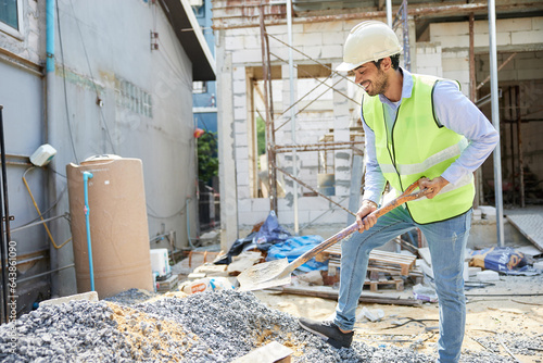 construction worker using shovel and digging sand at construction site