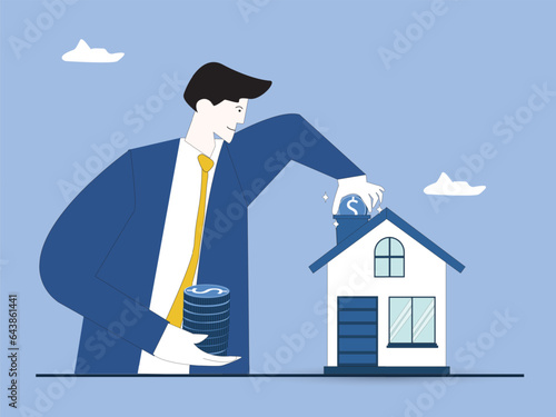 Self-build house construction loan. Mortgage for building concept. Man holding a stack of coins putting one coin into house roof building. Construction costs covered by bank. Investment in building.