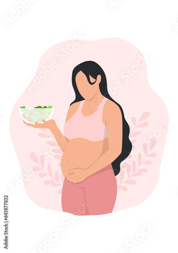 pregnant woman touching her belly and holding holding bowl of salad