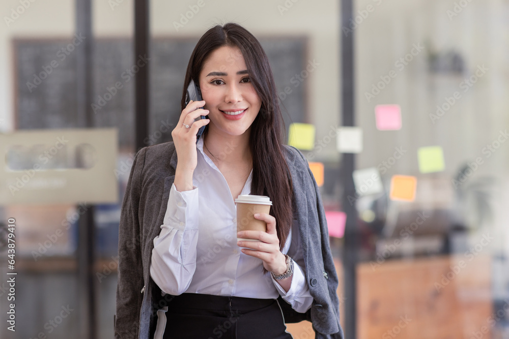 Portrait of young asian woman, company worker in phone smiling and call phone, standing over white background Portrait of young asian woman, company worker in phone smiling and call phone, standing over white background