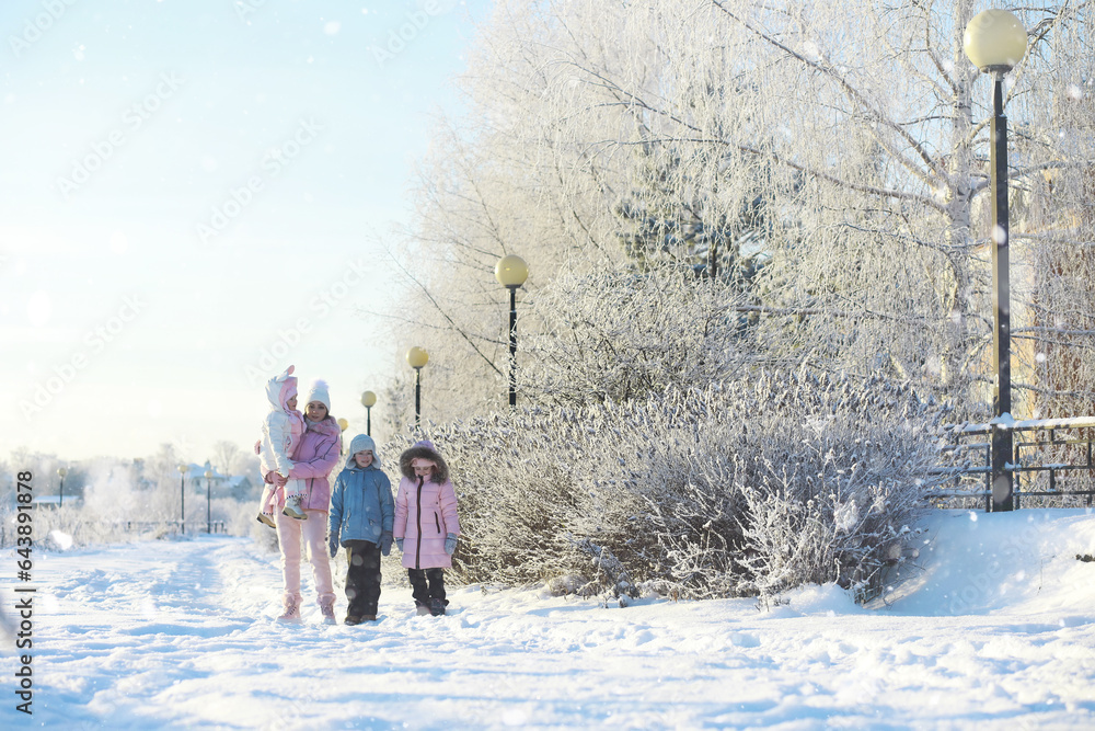 Winter walk on the street on a sunny frosty day. Family with children play snowballs in the park. Winter holidays and family vacation. Winter walk on the street on a sunny frosty day. Family with children play snowballs in the park. Winter holidays and family vacation.