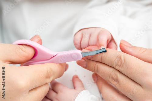 Safety in trimming newborn nails. Concept of detailed infant nail grooming