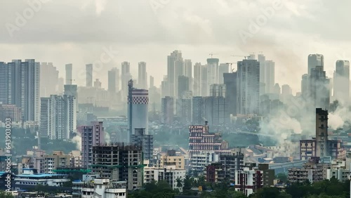 Aerial shot of cityscape with residential buildings close to factory zone with smoke from chimney in Mumbai. Air pollution Indian city area. Drone shot of industrial zone in Mumbai. Chembur drone view photo