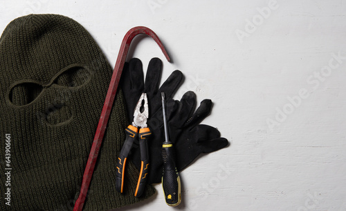 Картината върху платно Beige knitted balaclava, gloves,screwdriver and Crowbar,Collection of tools and equipment for theft,flat lay