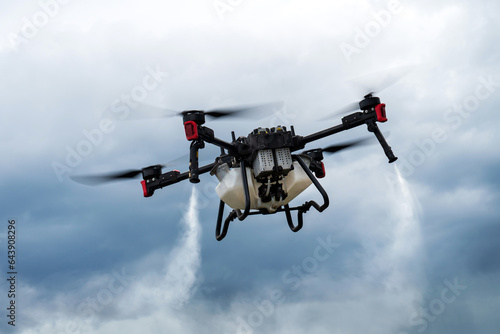Fototapeta Naklejka Na Ścianę i Meble -  Modern technologies in agriculture. industrial drone flies over a green field and sprays useful pesticides to increase productivity and destroys harmful insects. increase productivity