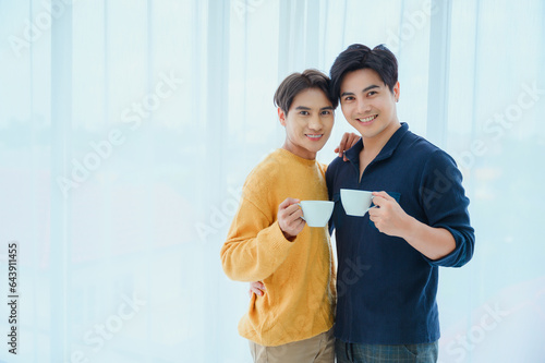 LGBQ concept of sexual diversity Asian gay couple drinking coffee on vacation in the morning photo