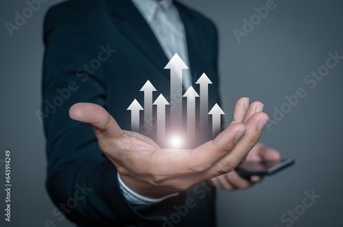 Businessman hand holding growth rising arrow up showing growing revenue and benefits. Successful plan or strategy, excellent sale or investment performance.