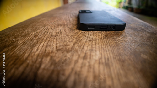 black smartphone on a wooden bench