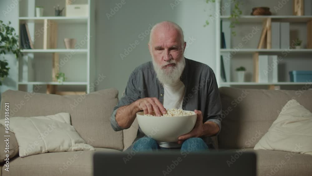 An Old Man Sitting on the Sofa, Eating Popcorn and Watching a Scary Movie. Movie Genres and Emotional Response. Online Cinemas. An Old Man Sitting on the Sofa, Eating Popcorn and Watching a Scary Movie. Movie Genres and Emotional Response. Online Cinemas.