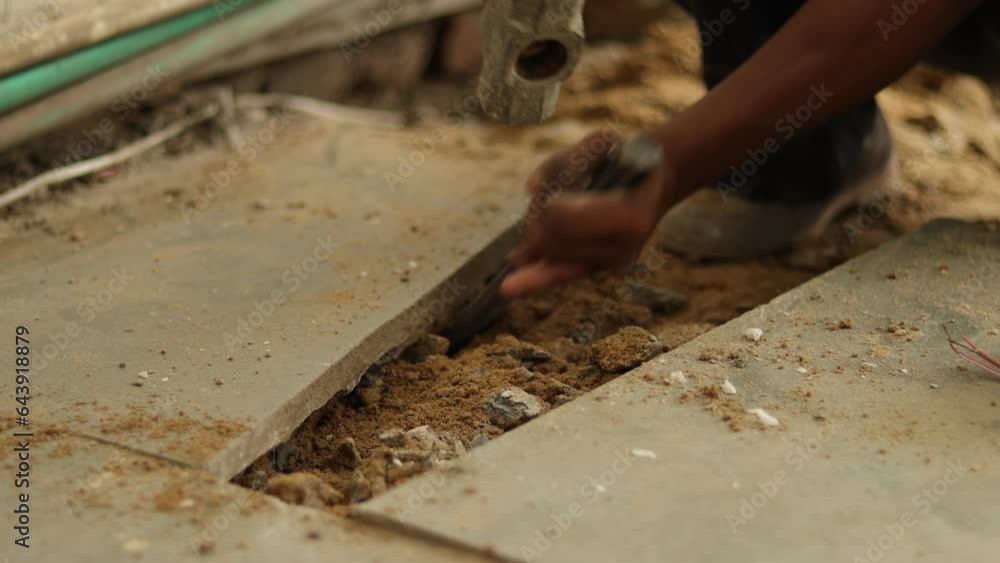 Architecture tile removing. Tiles Removing. Worker is removing broken tiles. Cleaning the tiles aside. Construction worker working hard, using hammer and chisel. Architecture tile removing. Tiles Removing. Worker is removing broken tiles. Cleaning the tiles aside. Construction worker working hard, using hammer and chisel.