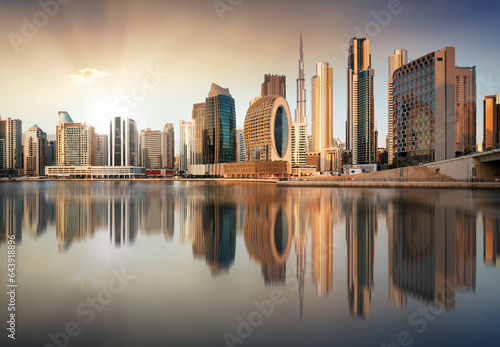 Fotografia Dubai skyline with reflection at dramatic sunset with sun in United Arab Emirate