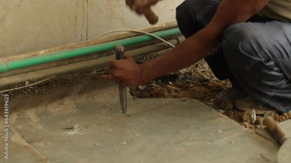 Architecture tile removing. Tiles Removing. Worker is removing broken tiles. Cleaning the tiles aside. Construction worker working hard, using hammer and chisel. Architecture tile removing. Tiles Removing. Worker is removing broken tiles. Cleaning the tiles aside. Construction worker working hard, using hammer and chisel.
