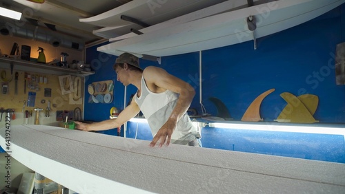 Photography Male surfboard shaper making surfboard in his workshop