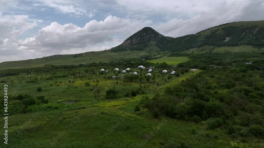 Aerial view of the complex of domed geodesic domes among the highlands. Glamping resort trend Aerial view of the complex of domed geodesic domes among the highlands. Glamping resort trend