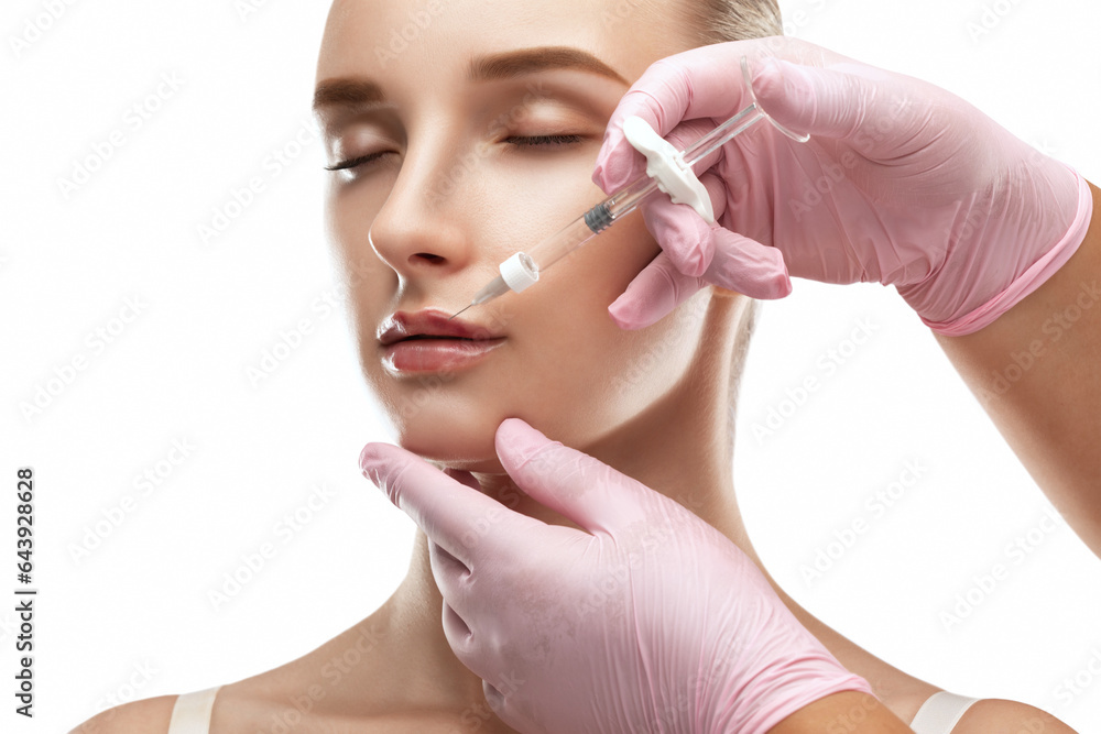 Cosmetologist does injections for lips augmentation anti wrinkle injections on the face of a beautiful woman. Female aesthetic cosmetology in a beauty salon. Cosmetologist does injections for lips augmentation anti wrinkle injections on the face of a beautiful woman. Female aesthetic cosmetology in a beauty salon.