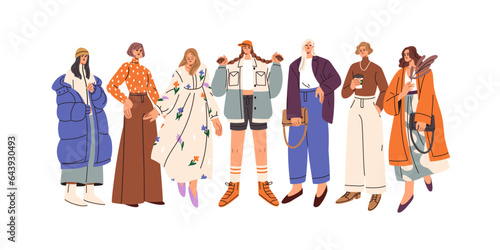 Young women group in fashion outfits. Stylish girls standing together, wearin...