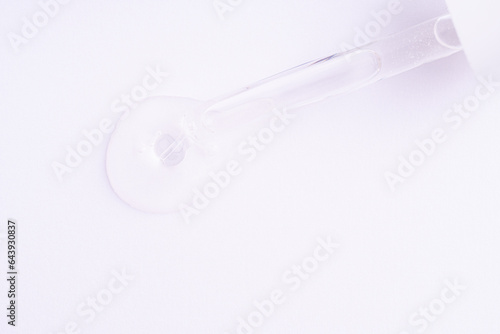 Serum gel in the pipette on white background. Cosmetic liquid dropper with bubbles, top view. © Tetiana