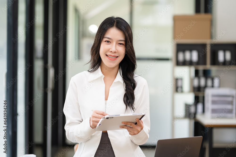 Female asian standing at the desk, looking to camera. Female asian standing at the desk, looking to camera.