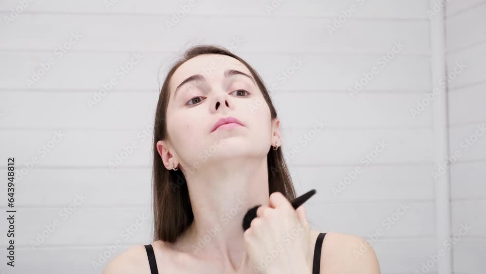 Woman does natural makeup applying powder on flawless fresh neck skin by brush. Girl looking at mirror. Conceal bruises and skin irregularities. Beauty face. Copy space. Morning visage preparation. Woman does natural makeup applying powder on flawless fresh neck skin by brush. Girl looking at mirror. Conceal bruises and skin irregularities. Beauty face. Copy space. Morning visage preparation.