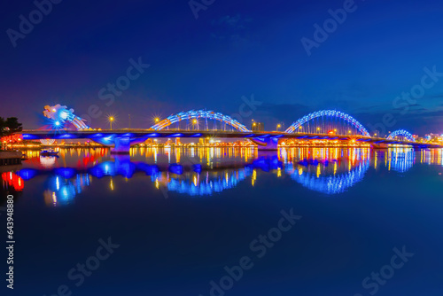 Foto Dragon River Bridge ( Rong Bridge) and administrative center building at night, the symbol of Da Nang city, Vietnam