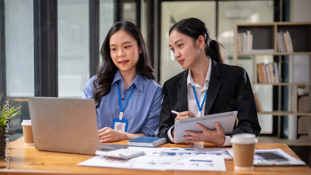 Two beautiful and focused young Asian businesswomen are sharing their project ideas. Two beautiful and focused young Asian businesswomen are sharing their project ideas.