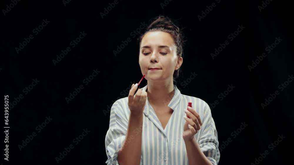 No time for personal things. Businesswoman doing lip makeup with lip gloss on black background. Water splashes on face. Concept of business, metaphor, overworking, stress, challenges, success No time for personal things. Businesswoman doing lip makeup with lip gloss on black background. Water splashes on face. Concept of business, metaphor, overworking, stress, challenges, success
