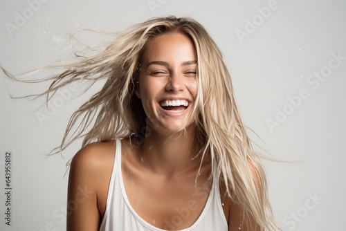 feamle model with wet hair smiling and shaking head photo