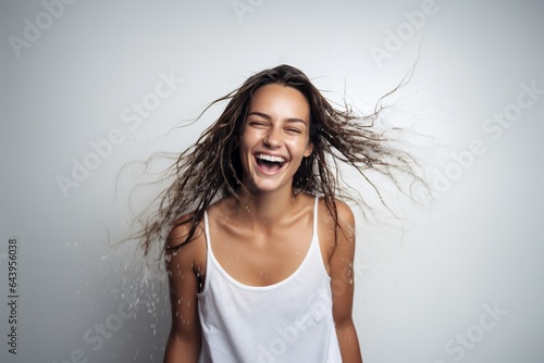 female model with brown hair wearing white tshirt and shaking wet hair