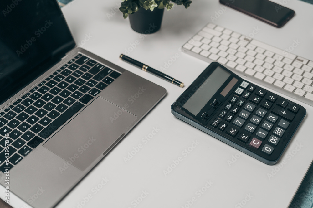 Office desk essentials top view of business objects including laptop, calculator, notebook, and pen organized workspace for success, Mock up, nobody Office desk essentials top view of business objects including laptop, calculator, notebook, and pen organized workspace for success, Mock up, nobody