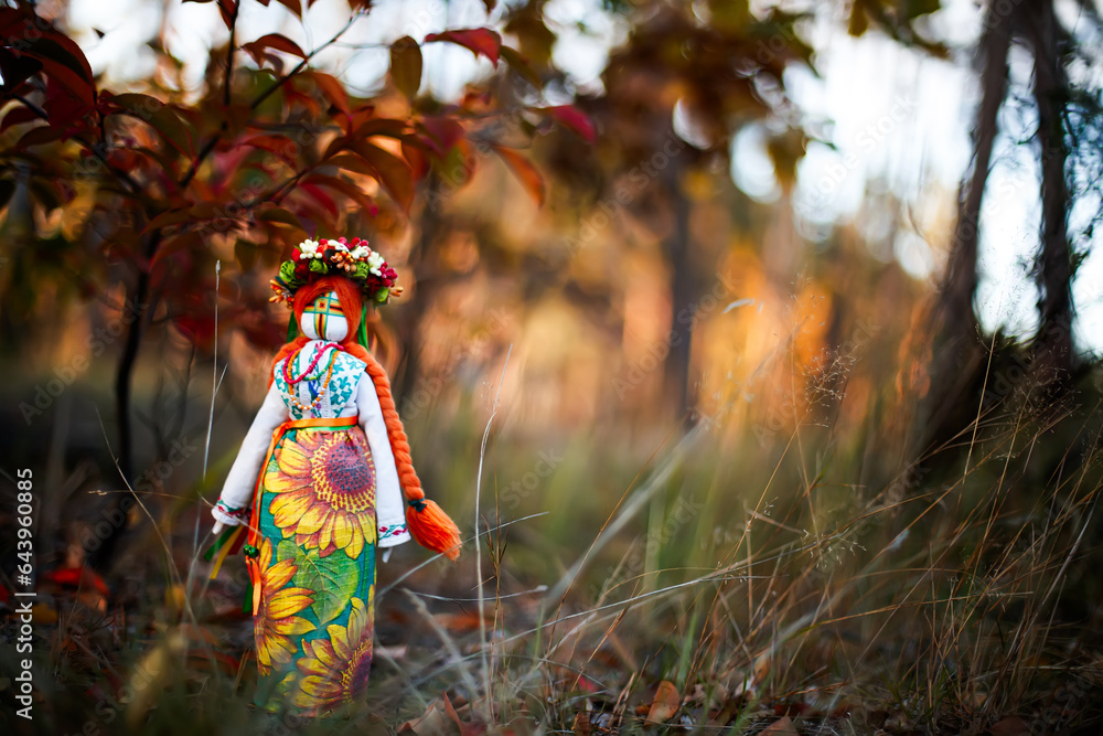 Rag doll in traditional Ukrainian costumeNear a tree with yellow autumn leaves at sunset Ukrainian handmade doll. War in Ukraine. Rag doll in traditional Ukrainian costumeNear a tree with yellow autumn leaves at sunset Ukrainian handmade doll. War in Ukraine.