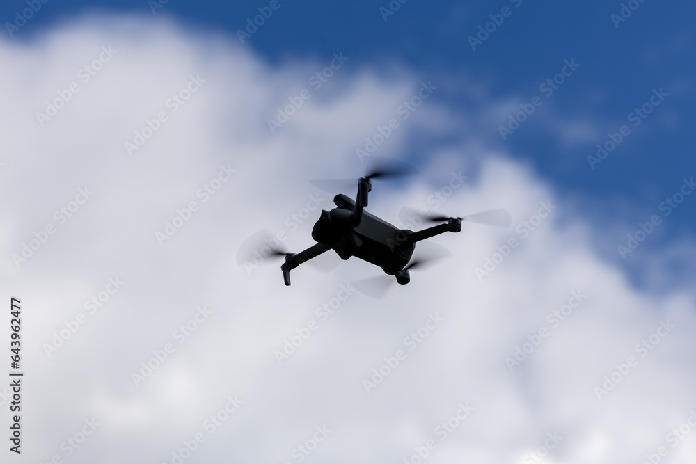 drone hovering in a bright blue sky. New technology in the aero photo shooting. drone hovering in a bright blue sky. New technology in the aero photo shooting.