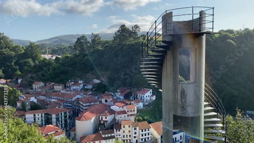 A tourist woman goes down the stairs of a tower in a viewpoint in Cudillero, Spain
