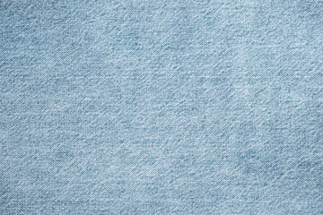 Texture of light blue jeans close up. Dark denim background.