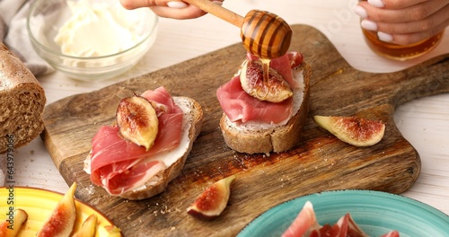 Bild auf Leinwand The process of making a sandwich with prosciutto and figs