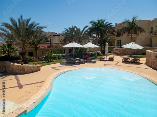 Beautiful view of the Egyptian hotel with palm trees, flowers and a swimming pool