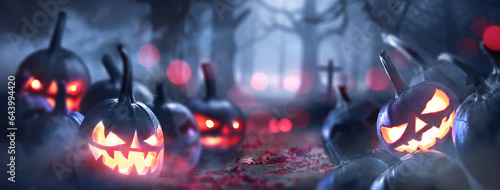 Quadro em tela Pumpkin lanterns with bright eyes on the background of a scary dark forest