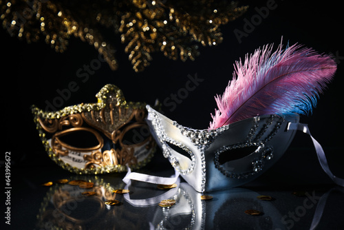 Carnival masks and feather on black background