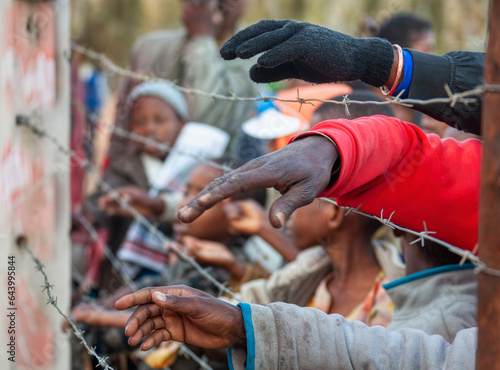 Φωτογραφία social unrest on the african continent, crowd of people hands seen through barbe