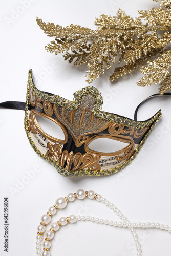 Carnival mask and beads on white background