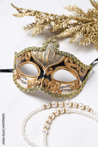 Carnival mask and beads on white background