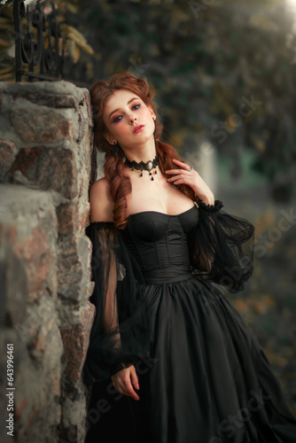 Portrait of magnificent Fashion gothic girl .Fantasy art work.Amazing red haired model in black dress looking at camera and posing.Fairytale about young princess 