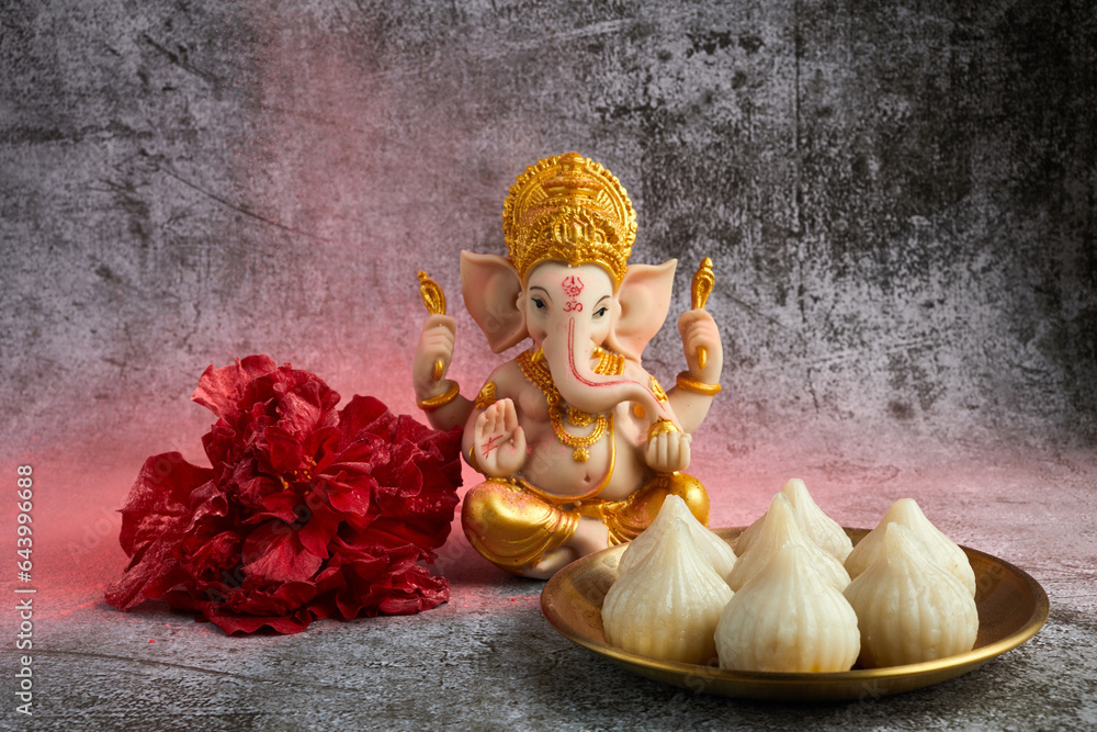 Idol of lord Ganesha with Modak Sweet Dish and flower. Ganesh chaturthi