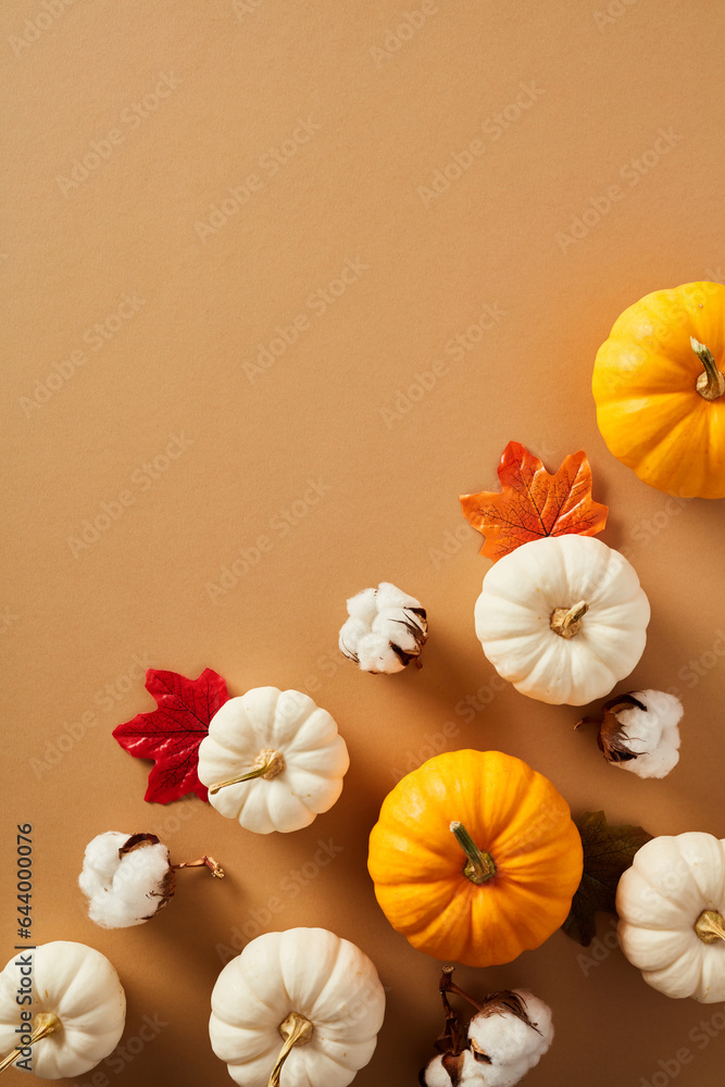Vertical flat lay composition with pumpkins, maple leaves, cotton on beige background. Autumn, fall, Thanksgiving concept.
