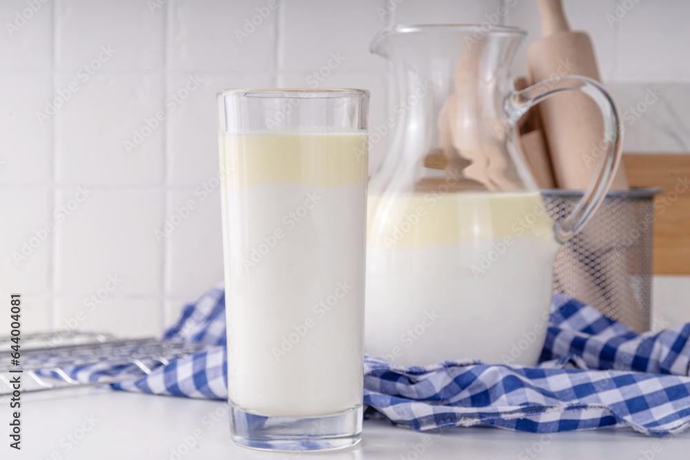 Non-Homogenized, whole milk, cream-top layered dairy product, Creamline Milk concept. Organic farm natural, unpasteurized milk in glass and jug, on white kitchen table copy space Non-Homogenized, whole milk, cream-top layered dairy product, Creamline Milk concept. Organic farm natural, unpasteurized milk in glass and jug, on white kitchen table copy space