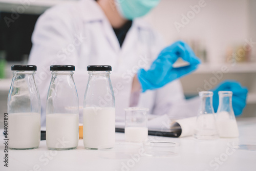 Nutritionist or scientist is looking a bottle of sample milk. Dairy milk test  research or analysis product
