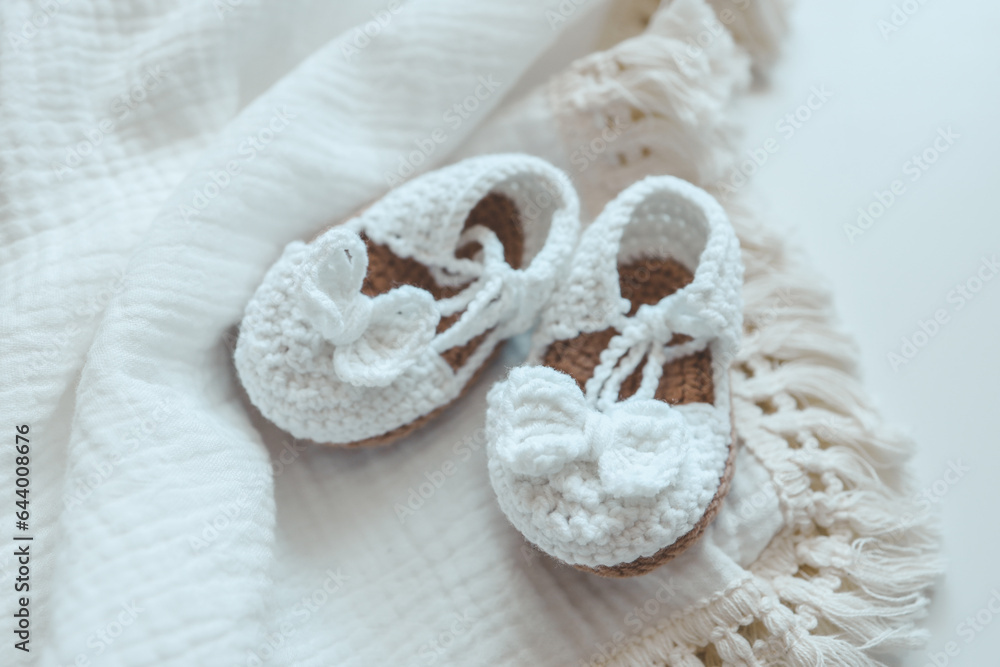 Baby muslin blanket and slippers top view on white background Baby muslin blanket and slippers top view on white background