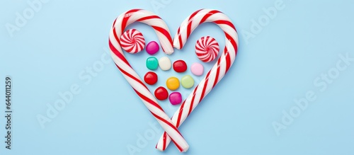 Festive multicolored candy cane without shadow on a isolated pastel background Copy space Decorative striped texture Top view