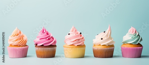 Colorful cupcakes with buttercream on isolated pastel background Copy space